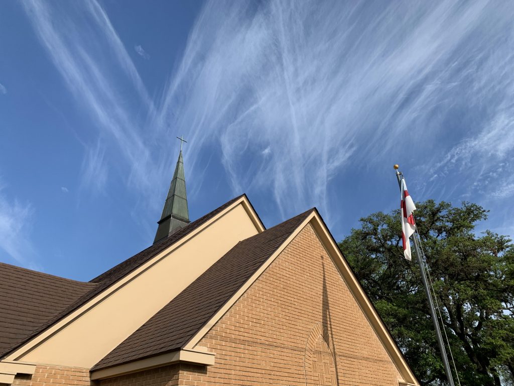 Photo of St. Bartholomew's church with wispy white clouds and a blue sky in the background.